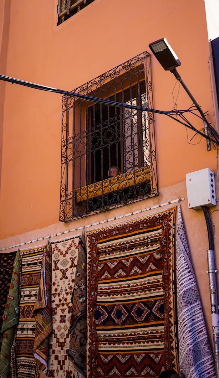 Traditional patterned rugs hanging outside in a Moroccan street market.
