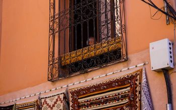 Traditional patterned rugs hanging outside in a Moroccan street market.